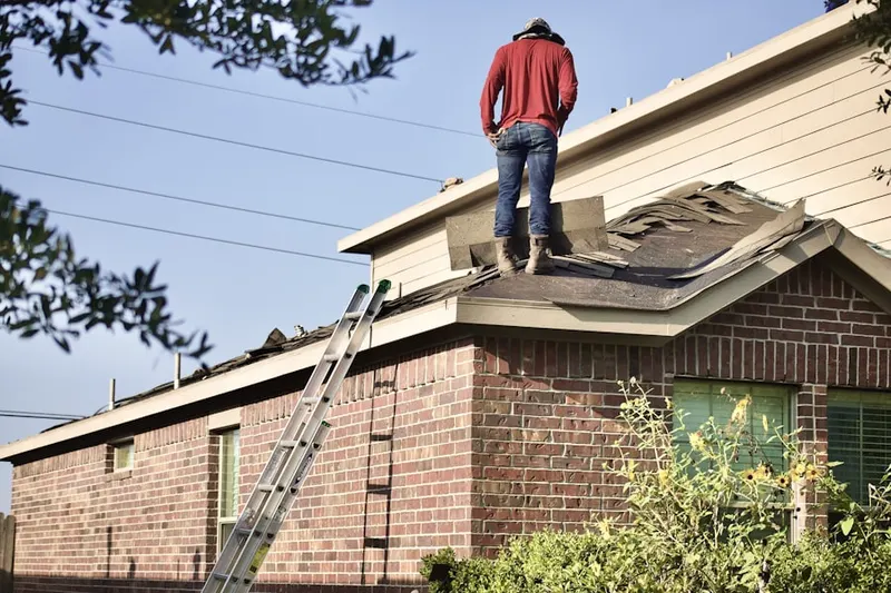 Professional roofer working on a residential roof in Rosecliff